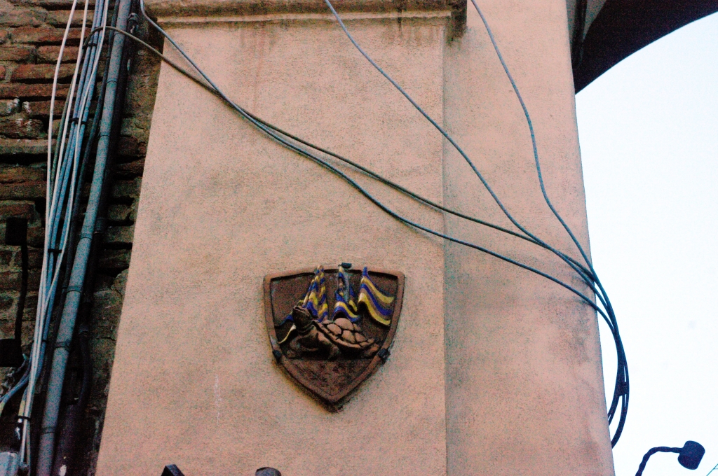 Границы районов Сиены (контрад) обозначены символами на домах.